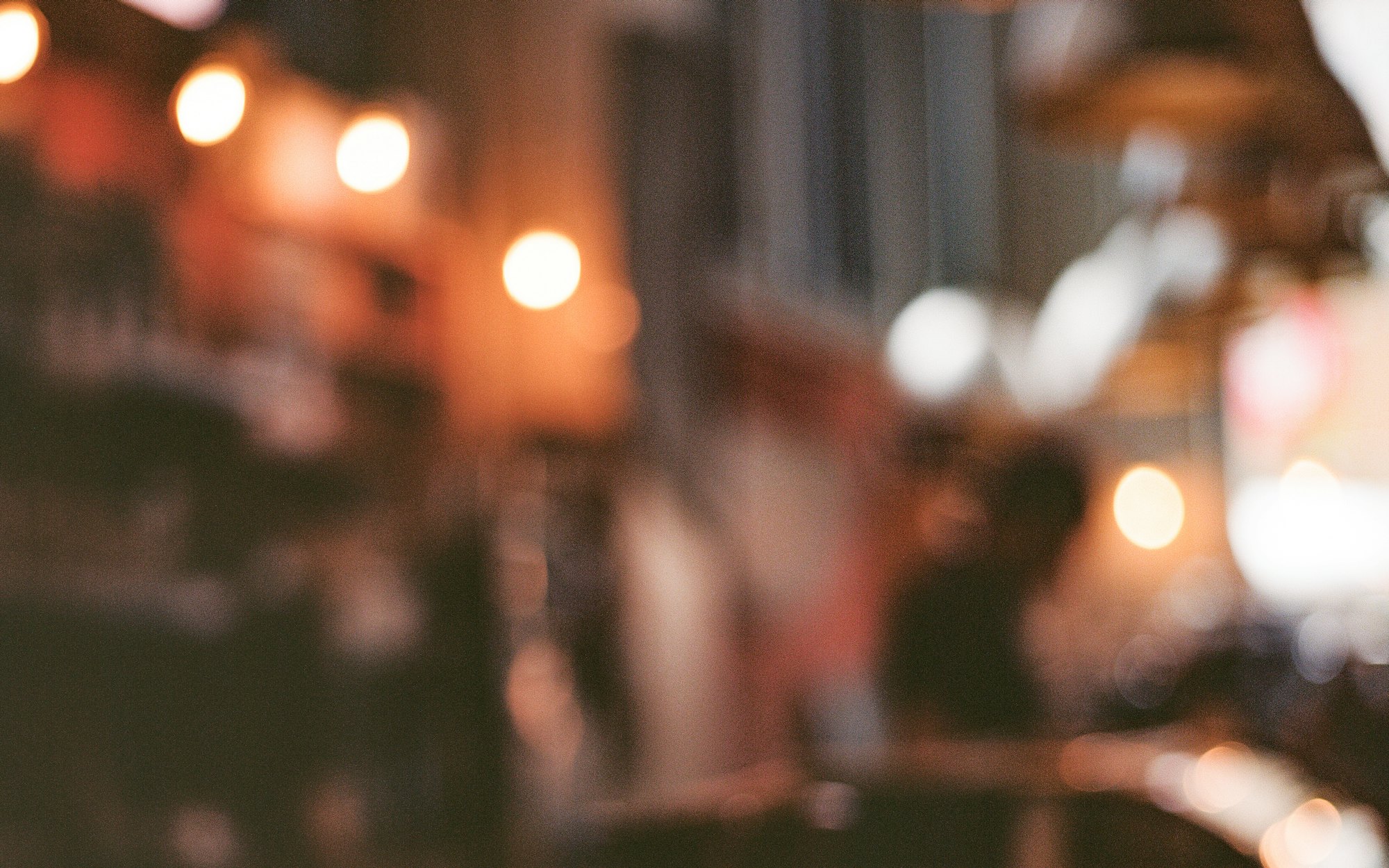 Warm lights blurred over a dark wooden counter