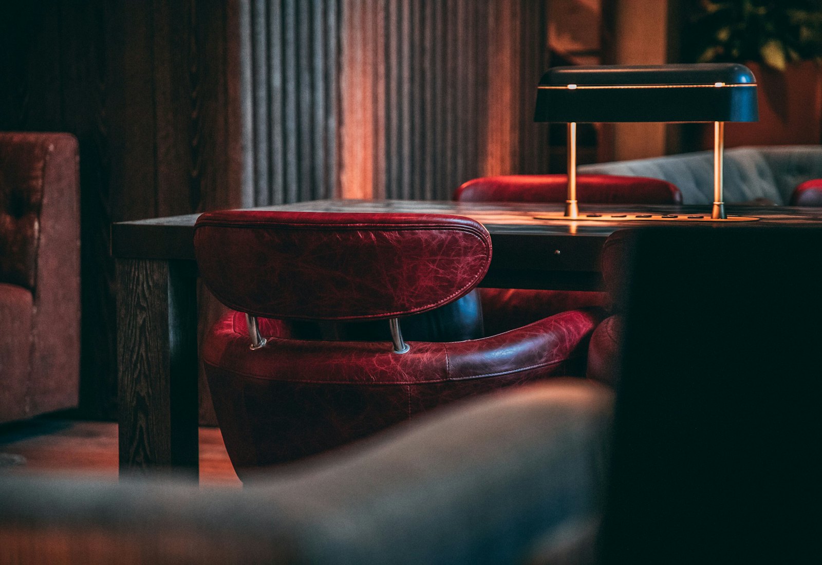 A dark leather booth lit by a single table lamp